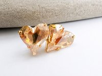 Close-up of champagne heart crystal stud earrings made with Swarovski Crystals, set in gold plated prong settings with brilliant faceted sparkle.