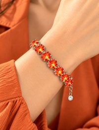 Woman wearing a bold orange crystal tennis  bracelet with large round Swarovski Rivoli stones on her wrist.