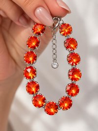 Close-up of sparkling Swarovski Orange Ignite Rivoli crystals showing the faceted 12mm stones and silver prong cup chain setting