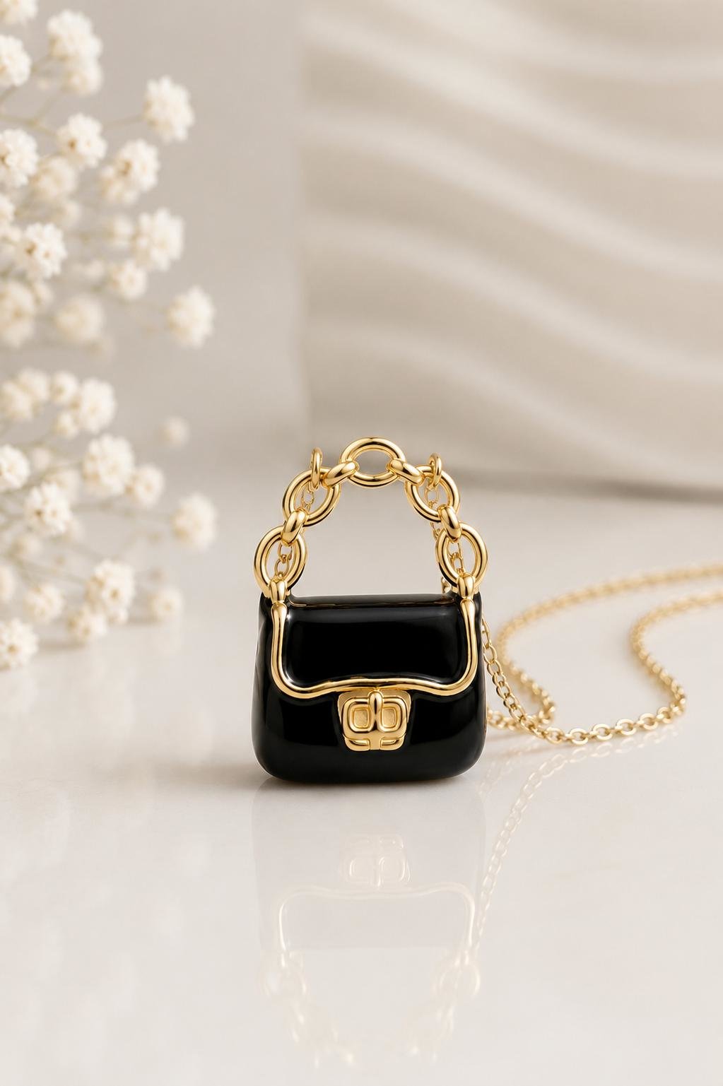 Mini handbag charm necklace displayed on an elegant surface.
