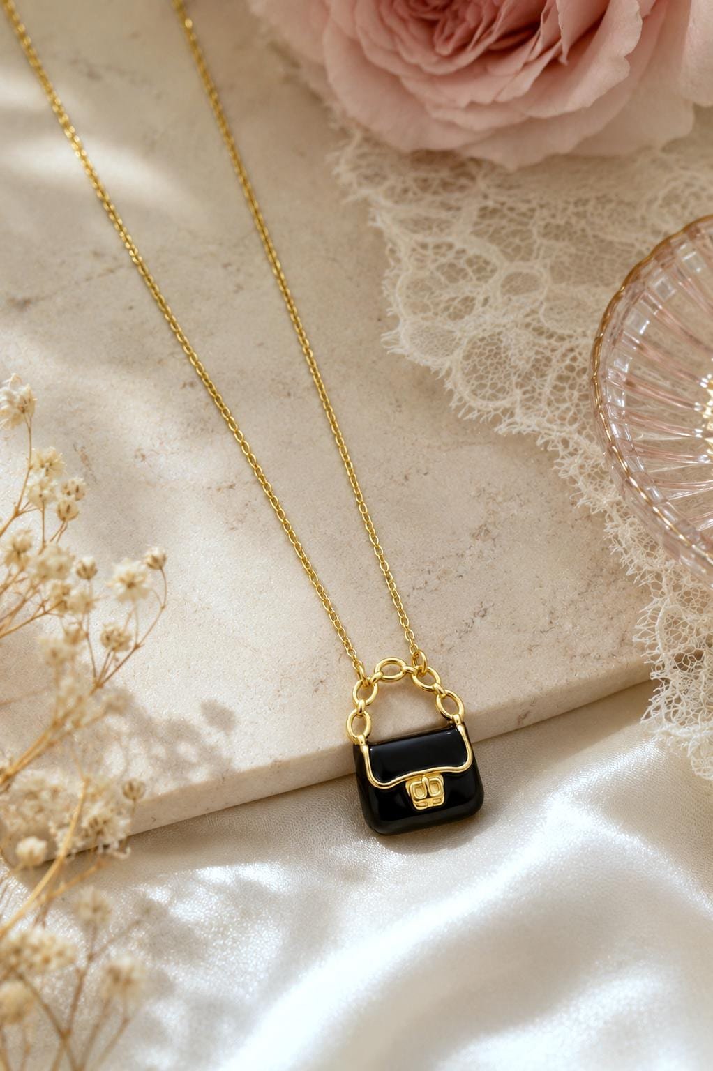 Close-up of a miniature handbag pendant with polished gold-plating accents.